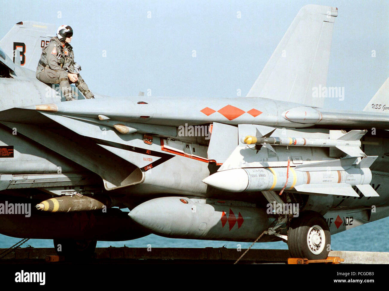 US Navy Lieutenant Steve Nevarez nimmt eine kurze Pause vom Stress des Flight Deck Operationen auf einer F-14B Tomcat Strike Fighter, Fighter Squadron eine Null Zwei (VF-102). Flugzeug ist bewaffnet mit einem AIM-9L Sidewinder kurze Reichweite, IR (Infrarot)-Rakete in die Luft; Ziel-54 C Phoenix long range Radar geführte, Luft-zu-Luft Raketen und eine Mk 82 500 lb. Bombe. Die Atomgetriebenen Flugzeugträger GEORGE WASHINGTON (CVN 73) und VF-102 sind derzeit die Durchführung von Operationen im Persischen Golf zur Unterstützung der UN-Sanktionen gegen den Irak. Operation SOUTHERN WATCH, 2. Dezember 1997. Stockfoto