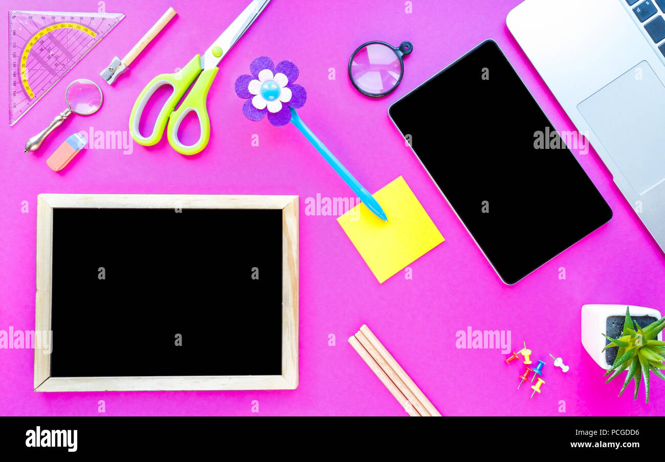 Feminine Büro Schule flach, schwarzes Brett, Tablet-PC und Laptop auf rosa Hintergrund Stockfoto