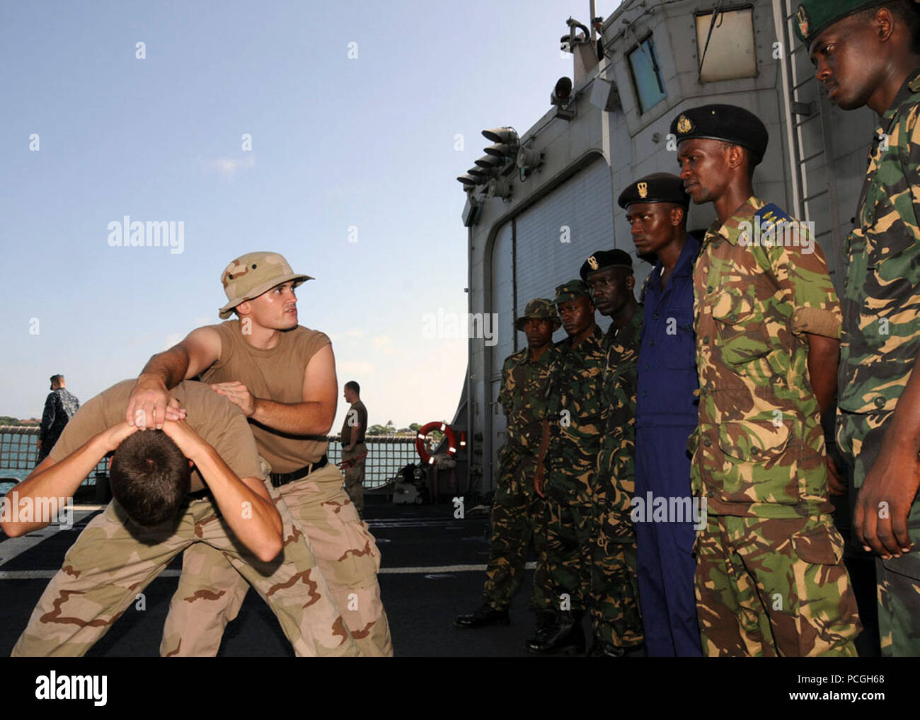 Petty Officer 3rd Class Michael Bernier, eine Quartiermeister und Afrika Partnerschaft Bahnhof Ost Besuch, Board, Durchsuchung und Beschlagnahme (VBS) Lehrer, zeigt Suchtechniken tansanischen Seeleute an Bord der APS East-Platform USS Nicholas (FFG 47) in Dar Es Salaam, Tansania. VBSS gehört zu einer Reihe von maritimen Schulungen an Bord Nikolaus und das high-Speed-Schiff Swift (HSV-2) für Mitglieder der tansanischen Völker Defense Force angeboten. APS-Ost ist in Tansania zur Teilnahme an maritimen und kulturellen Austausch mit der tansanischen Marine und Häfen in Dschibuti, Kenia, Ta besuchen Stockfoto