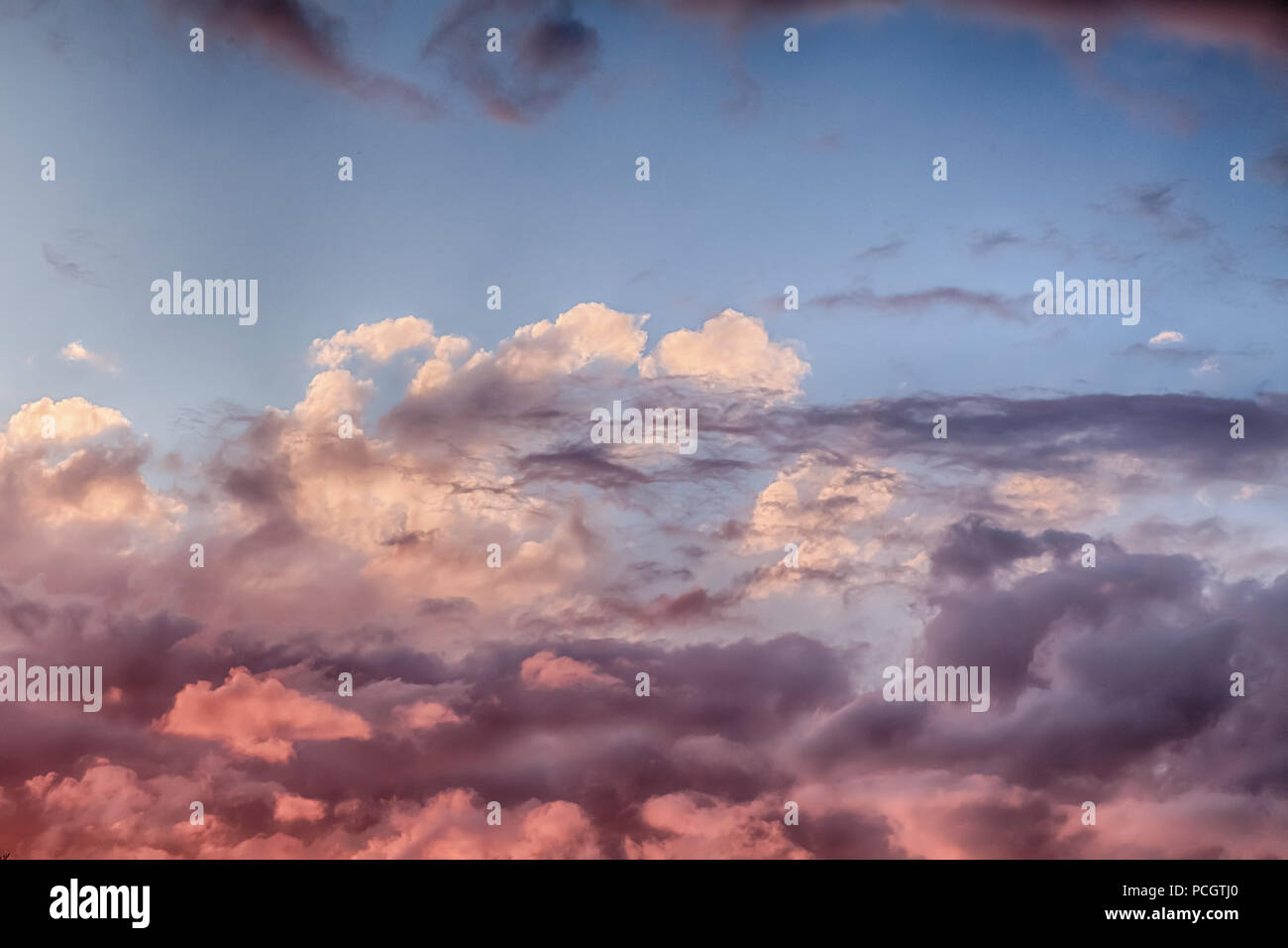 Schöne Wolken und blauer Himmel bei Sonnenuntergang mit rosa und violetten Tönen über England UK. Cloudscape und skyscape Hintergrund Stockfoto