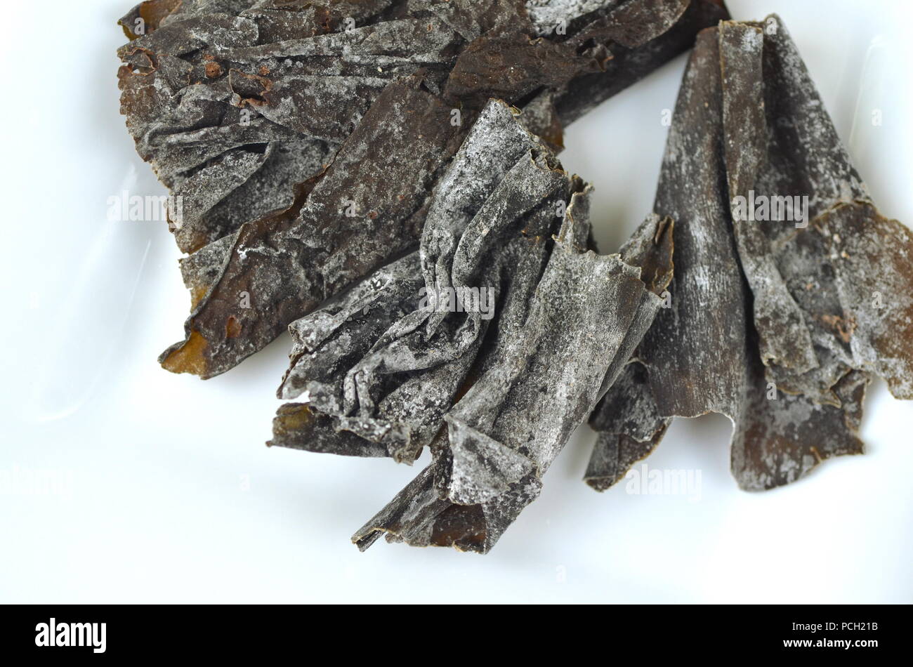 Blick von oben auf die getrockneter Seetang Detail: Kelp. Auf weiß isoliert. Nährstoff reichen vegan, roh und gesunde Gemüse. Stockfoto