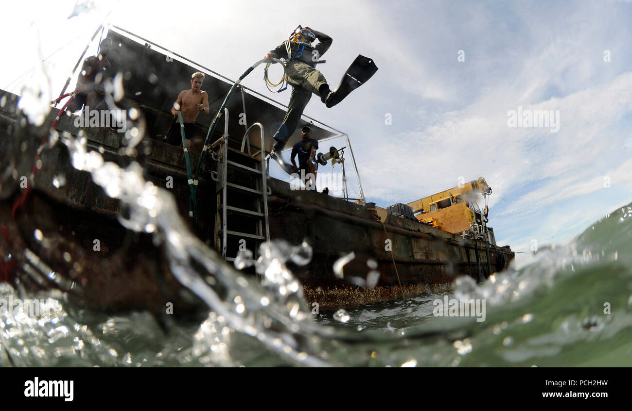 Petty Officer 2nd class Jessie Trujillo, ein Navy diver und Mitglied der Mobilen Tauchen und Bergung Unit 1, springt von einem lastkahn Für eine Oberfläche Versorgung tauchen die Unterstützung einer Joint POW/MIA Accounting Command recovery Mission. Stockfoto