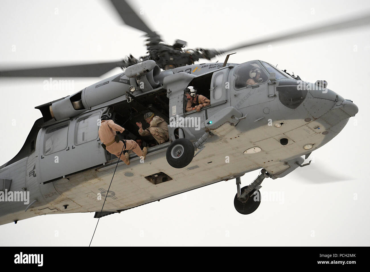 Bahrain (30. Juni 2011) eine Marine die Beseitigung von Explosivstoffen Techniker Task Group (TG) 56,1 springt von einem Hubschrauber während eines taktischen Personal insertion während Hubschrauber Seilaufhängung Ausbildung zugewiesen. TG 56.1 unterstützt Maritime Security Operations und Theater Sicherheit Zusammenarbeit in den USA 5 Flotte Verantwortungsbereich. Stockfoto