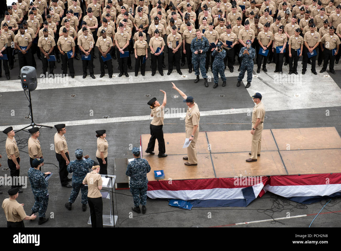 Pazifik (30 Mai 2017) eine neu frocked Petty Officer erreicht hohe Fünf Command Master Chief Spike Anruf während eines frocking Zeremonie auf dem Flugdeck der Flugzeugträger USS Theodore Roosevelt (CVN 71). Theodore Roosevelt ist derzeit pier Seite in ihren Heimathafen San Diego günstig nach der vor kurzem die Vollendung der maßgeschneiderten Ausbildung an Land, die Verfügbarkeit und die abschließende Bewertung Problem (TSTA/FEP). Stockfoto