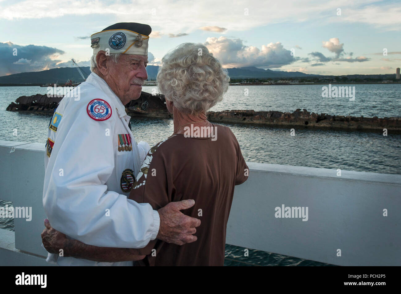 PEARL HARBOR (31. 6, 2013) die Delton Walling, ein Überlebender des Dez. 7, 1941 Angriff auf Pearl Harbor, und Joan Bohl beachten Sie die Reste der USS Utah (AG16) während ein Sonnenuntergang an der USS Arizona Memorial am Joint Base Pearl Harbor-Hickam. Während der Zeit des Angriffs, die Wände war ein Petty Officer und Einweisende angeschlossen an das Schlachtschiff USS Pennsylvania (BB 38), anschließend trocken - im Hafen angedockt und wurde zur Kommunikation Kraft von Adm zugeordnet. Mann E. Kimmell, Kommandant der pazifischen Flotte. Stockfoto