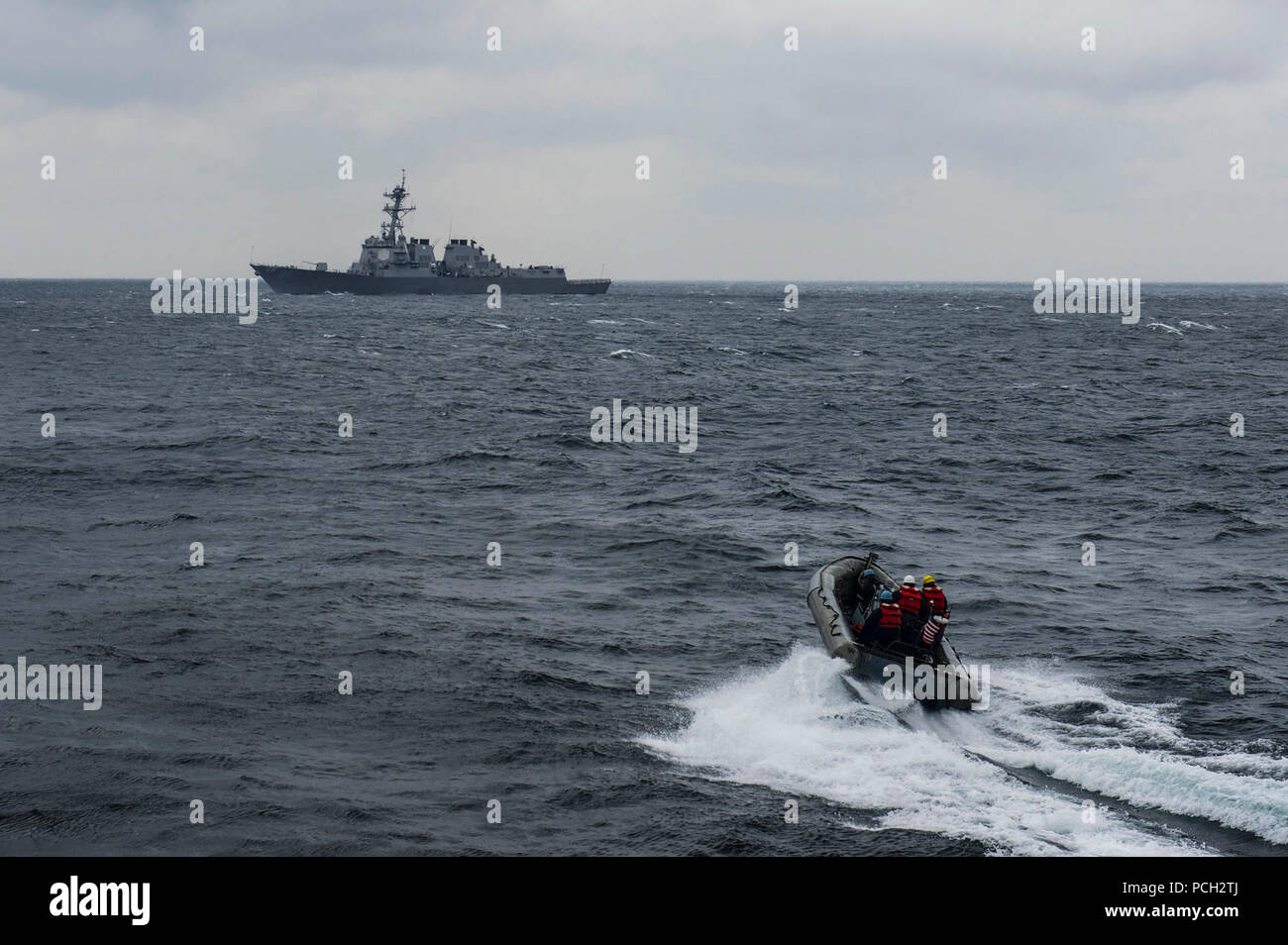 Gewässer südlich von Japan (April 8, 2015) eine starre - Rumpf Schlauchboot der Arleigh-Burke-Klasse geführte-missile Cruiser USS Mustin (DDG89) Transite zum Arleigh-burke-Klasse geführte-missile Cruiser USS Preble (DDG88) für ein Personal übertragen. Mustin ist auf Patrouille in den USA 7 Flotte der Verantwortung für Sicherheit und Stabilität in der Indo-Asia-Pazifik-Region. Stockfoto