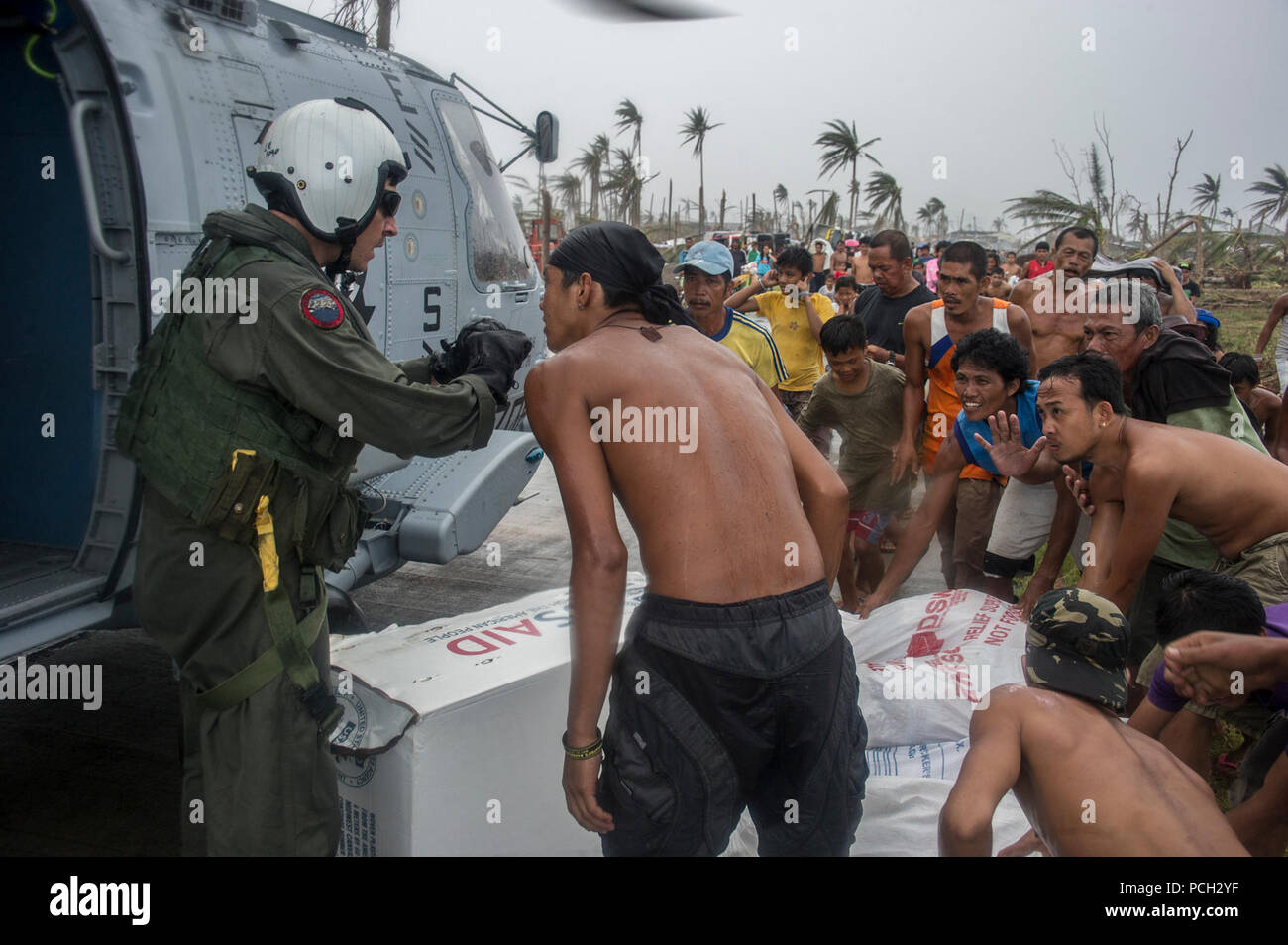 HENANE, Provinz Eastern Samar, die Republik der Philippinen (Nov. 17, 2013) Naval Aircrewman (taktische Hubschrauber) 1. Klasse Logan Robertson, links, von Marianna Fla., spricht mit philippinischen Zivilisten nach ihren Hilfsfluegen in ihrem Dorf während des Betriebs Damayan. Die George Washington Carrier Strike Group in Abstimmung mit den 3d-Marine Expeditionary Brigade ist die Unterstützung der philippinischen Regierung in laufenden Hilfsmaßnahmen in Reaktion auf die Folgen der Super Typhoon Haiyan/Yolanda in der Republik der Philippinen. Stockfoto