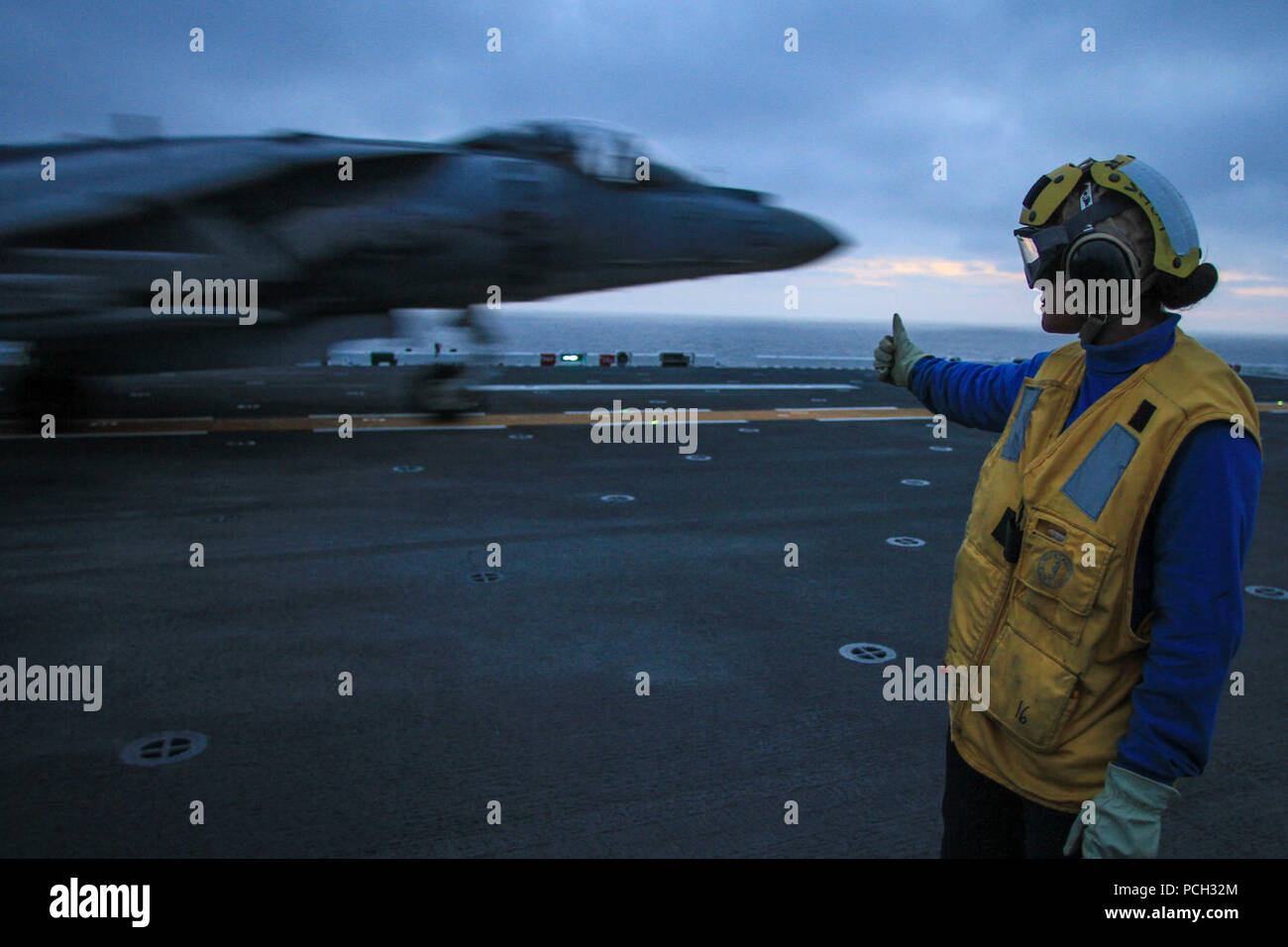 Pazifik (25. März 2013) ein Matrose gibt Richtung an ein AV-8B Harrier zu Marine Attack Squadron (VMA) 214 während Flugbetrieb zugewiesen an Bord der Amphibisches Schiff USS Boxer (LHD4). Boxer ist unterwegs Schulungen vor der Küste von Südkalifornien. Stockfoto