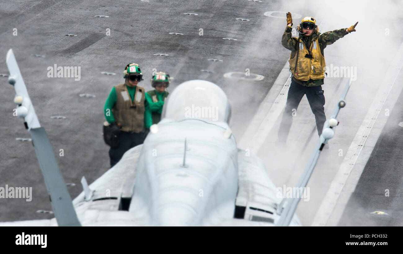 Pazifik (15. Juni 2015) ein Seemann leitet eine F/A-18C Hornet der Gladiatoren von Strike Fighter Squadron (VFA) 106 Anhang für den Start von dem Flugzeugträger USS John C Stennis (CVN 74). John C Stennis befindet sich in eine betriebliche Ausbildung in Vorbereitung für zukünftige Bereitstellungen. Stockfoto