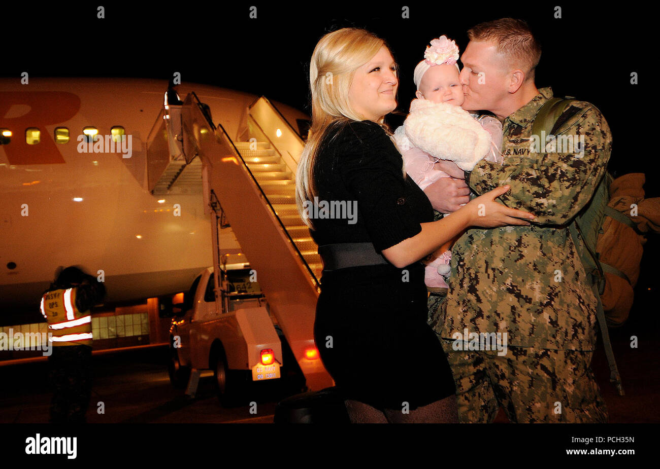 OAK Harbor, Washington (Nov. 27, 2012) Naval Air Besatzungsmitglieder 2. Klasse Ryan Roberson begrüßt seine Frau und zum ersten Mal, seine 5 Monate alte Tochter, während der Homecoming der Patrol Squadron (VP) 46. Matrosen zu VP-46 Home zu Naval Air Station Whidbey Island von einem sechsmonatigen Einsatz in die USA 5 Flotte Verantwortungsbereich zurück zugeordnet. America's Sailors sind Warfighters, eine schnelle und flexible Kraft weltweit eingesetzt. Beteiligen Sie sich an der Diskussion über soziale Medien mit #Warfighting. Stockfoto