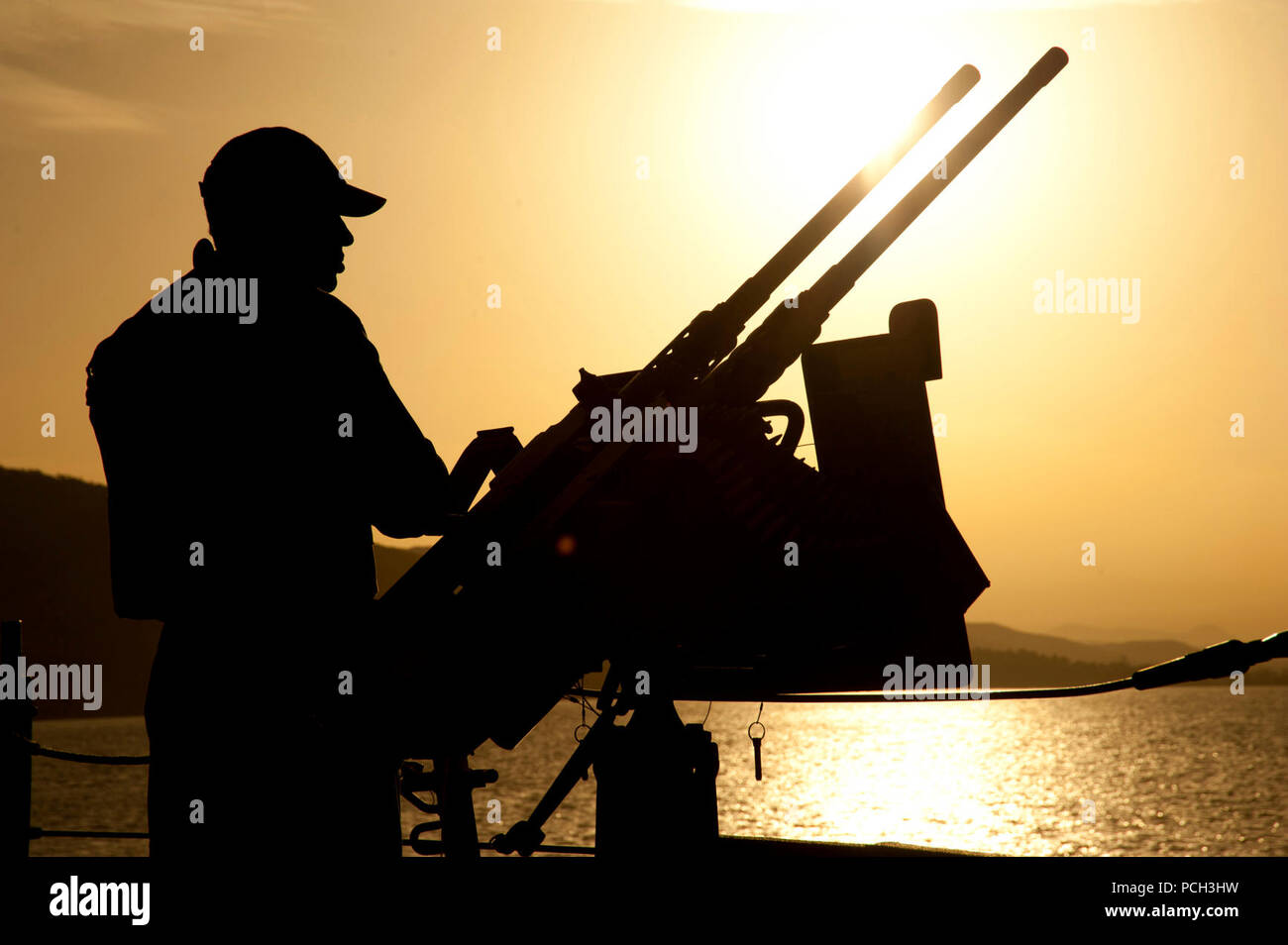 Die SOUDA BUCHT, Griechenland (10. März 2013) Feuer Controlman 3. Klasse Jon Browne mans ein Maschinengewehr an Bord der geführte Anti-raketen-Zerstörer USS Barry (DDG52) als das Schiff in die Bucht von Souda, Griechenland unterwegs erhält, nach einem Hafen besuchen. Barry, homeported aus Norfolk, Virginia, ist in die USA 6 Flotte der Verantwortung zur Unterstützung der Maritime Security Operations und Theater Sicherheit Zusammenarbeit bereitgestellt werden. Stockfoto