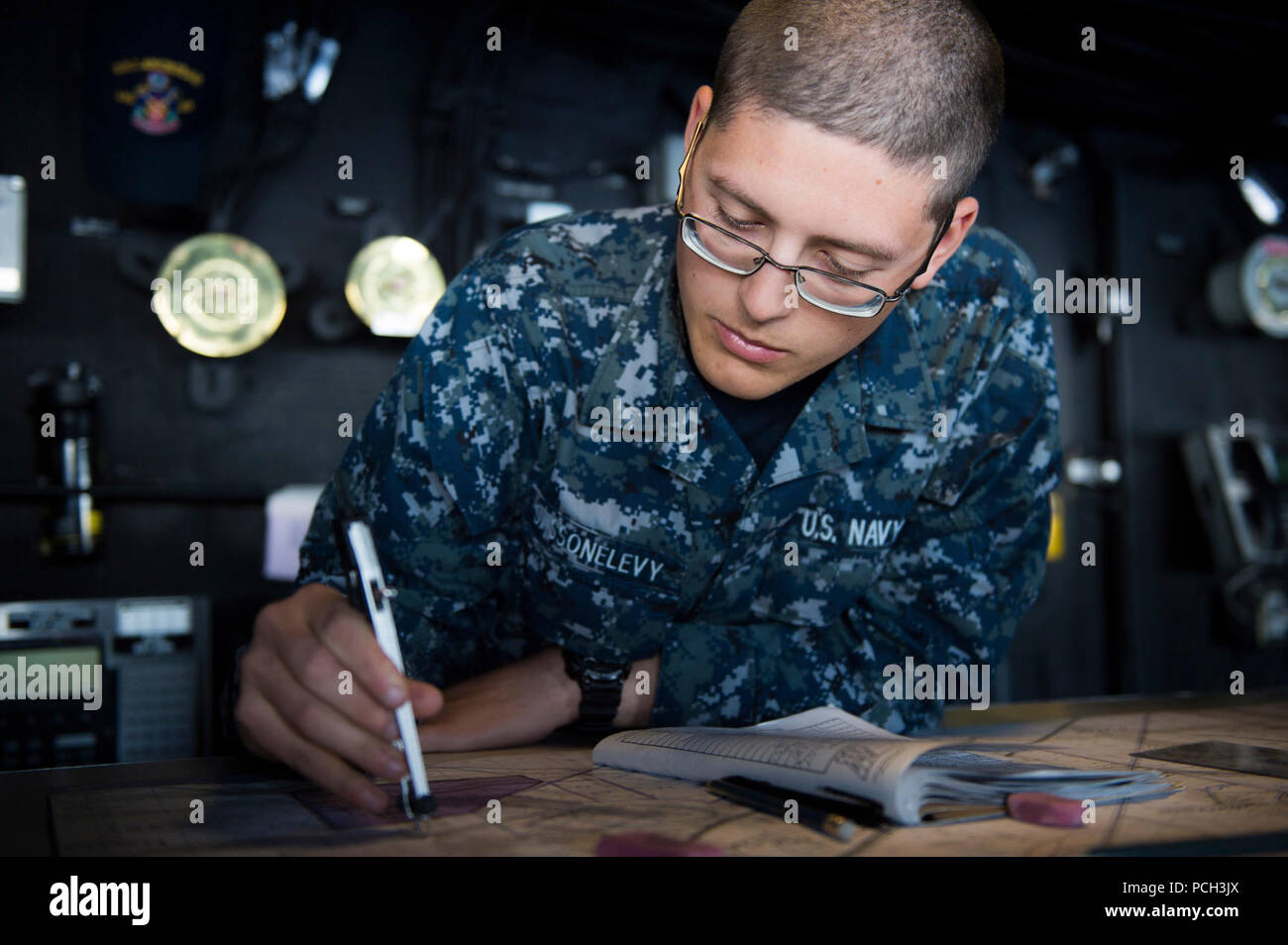 Pazifik (23. März 2015) Quartermaster Seaman Apprentice Brandon Sassonlevy, von Plainview, N.Y., Charts, einen Kurs auf der Brücke der San Antonio-Klasse amphibious Transport dock Schiff USS Anchorage LPD (23) Während eines simulierten Strait Transit. Anchorage ist unterwegs an einem Composite Trainingsgerät Übung mit der Essex Amphibious Ready Gruppe. Stockfoto