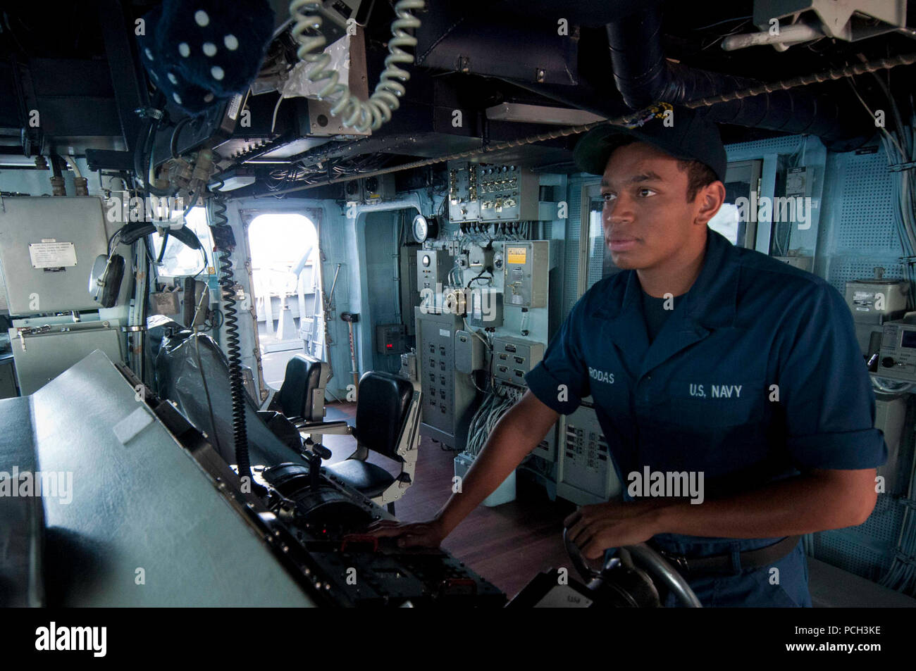 Philippinischen MEER (Nov. 9, 2012) Seaman Recruit Melvin Rodas, der Geführten zugeordnet Anti-raketen-Zerstörer USS Mustin (DDG89), steuert das Schiff auf der Brücke. Mustin ist Teil der George Washington Carrier Strike Group gegründet aus Yokosuka, Japan, und leitet eine Patrouille der westlichen Pazifik zur Unterstützung der regionalen Sicherheit und Stabilität in der asiatisch-pazifischen Region. Stockfoto