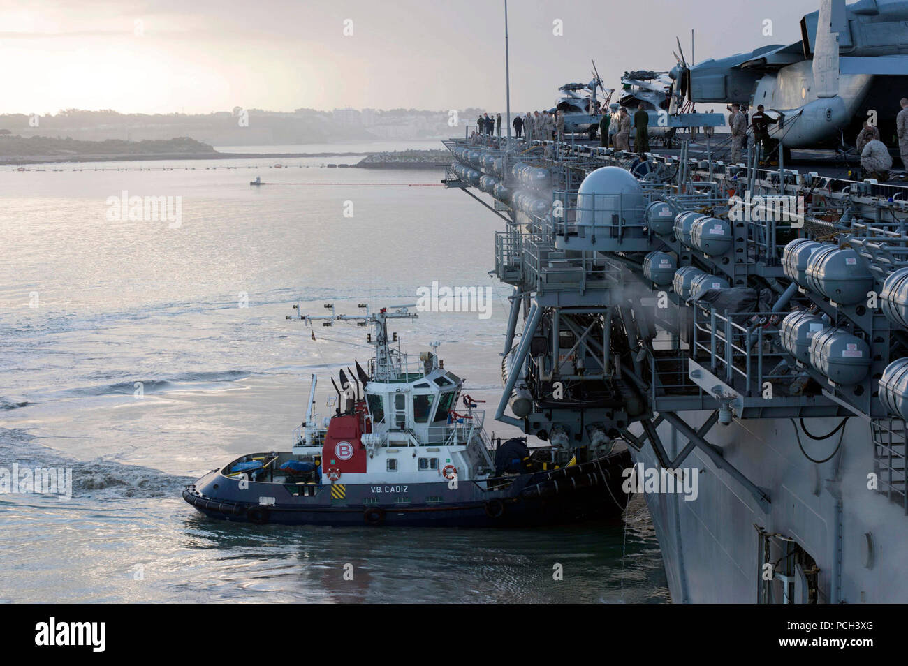 ROTA, Spanien (25. März 2013) einen Schlepper Manöver der Amphibisches Schiff USS Kearsarge (LHD 3), wie es in den Hafen in Rota, Spanien. Kearsarge ist Teil der Kearsarge Amphibious Ready Gruppe auf einer geplanten Einsatz unterstützen Maritime Security Operations und Theater Sicherheit Zusammenarbeit im Sechsten Flotte Verantwortungsbereich. Stockfoto