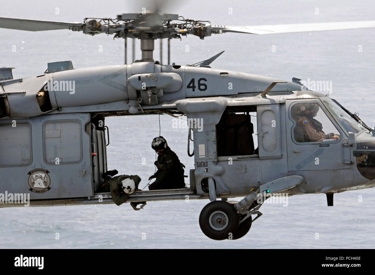 Ein U.S. Navy aircrewman prüft die Cargo Anhänger eines MH-60S Seahawk Helikopter Hubschrauber Meer Combat Squadron (HSC) 23 während einer vertikalen Auffüllung zugewiesen-auf-See zwischen dem schnellen Combat support ship USNS Brücke (T-AOE 10) und amphibische Landung dock Schiff USS Comstock (LSD 45) im Arabischen Golf, 17. Mai 2011. Comstock unterstützt Maritime Security Operations und Theater Sicherheit Zusammenarbeit in den USA 5 Flotte Verantwortungsbereich. Stockfoto