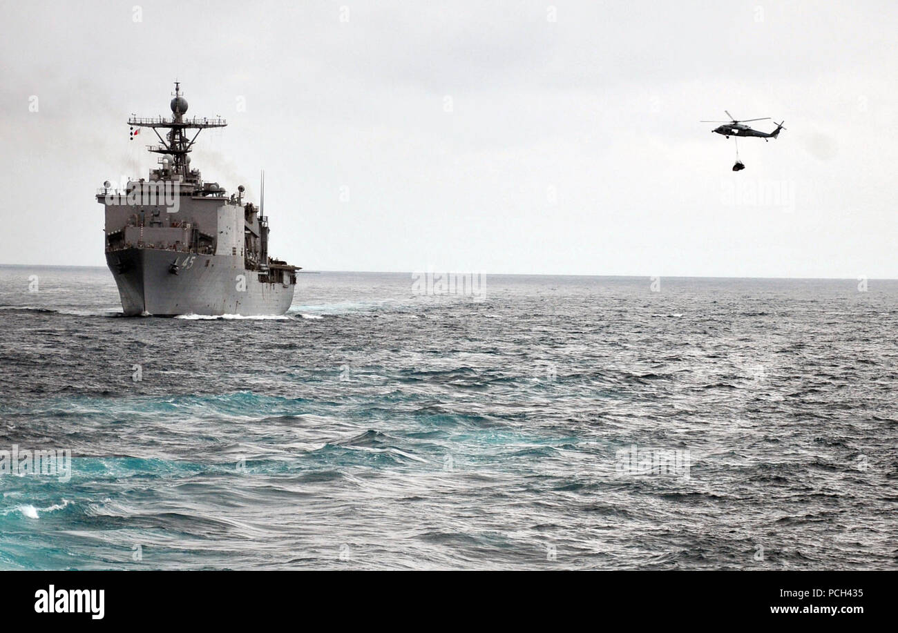 Ein U.S. Navy MH-60 Seahawk Hubschrauber der Hubschrauber Meer Combat Squadron (HSC) 23 liefert die amphibische Landung dock Schiff USS Comstock (LSD 45) vom Merchant Marine Öler und Supply ship USNS Rappahannock (T-AO 204) im Pazifischen Ozean, den 17. März 2011 beigefügt. Comstock ist Teil der Boxer Amphibious Ready Gruppe. ( Stockfoto
