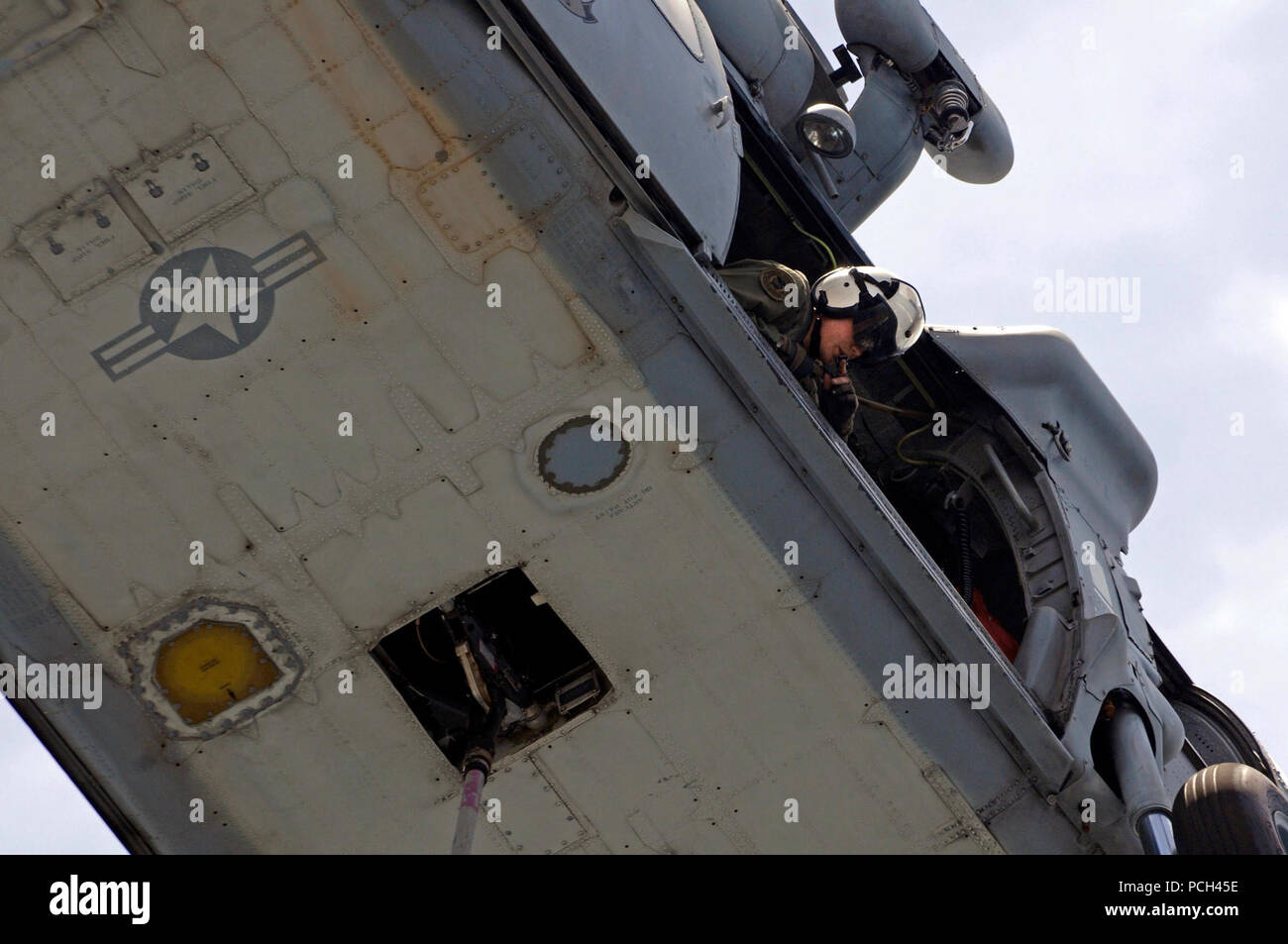 Ein U.S. Navy Naval Air crewman überprüft, um zu sehen, dass ein MH-60S Seahawk Helikopter Hubschrauber Meer Combat Squadron (HSC) 23 zugeordnet klar von der Flight Deck ist während einer vertikalen Nachschub zwischen Military Sealift Command schnell Combat support ship USNS Brücke (T-AOE 10) und amphibische Landung dock Schiff USS Comstock (LSD 45) im Persischen Golf Mai 17, 2011. Comstock wurde Unterstützung für Maritime Security Operations und Theater Sicherheit Zusammenarbeit in den USA 5 Flotte Verantwortungsbereich. Stockfoto