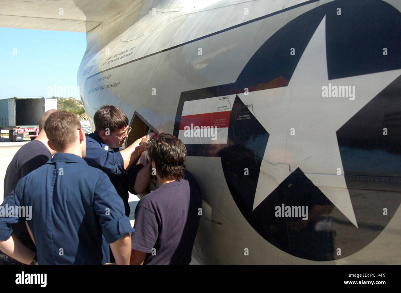 Guantánamo Bay, Kuba - Navy Chief Petty Officer Robert Hofman Reparaturen eine Rampe Verriegelungsstellglied Halterung auf einem C-2 Greyhound Aircraft Carrier onboard Lieferung als Navy Airman Christopher Steffen, Marine Petty Officer 3rd Class Josh Brennan und Marine Petty Officer 3rd Class Kristen McGarvey Blick am U.S. Naval Station Guantanamo Bay Flugplatz, Jan. 19, 2010. Die Flieger sind Teil der Flotte Logistik Squadron VRC-40 und sind zur Unterstützung der Operation einheitliche Antwort bereitgestellt, die Bereitstellung humanitärer Hilfe für Haiti. (JTF Guantanamo Stockfoto Guantánamo Bay, Kuba - Navy Chief Petty Officer Robert Hofman Reparaturen eine Rampe Verriegelungsstellglied Halterung auf einem C-2 Greyhound Aircraft Carrier onboard Lieferung als Navy Airman Christopher Steffen, Marine Petty Officer 3rd Class Josh Brennan und Marine Petty Officer 3rd Class Kristen McGarvey Blick am U.S. Naval Station Guantanamo Bay Flugplatz, Jan. 19, 2010. Die Flieger sind Teil der Flotte Logistik Squadron VRC-40 und sind zur Unterstützung der Operation einheitliche Antwort bereitgestellt, die Bereitstellung humanitärer Hilfe für Haiti. (JTF Guantanamo Stockfoto