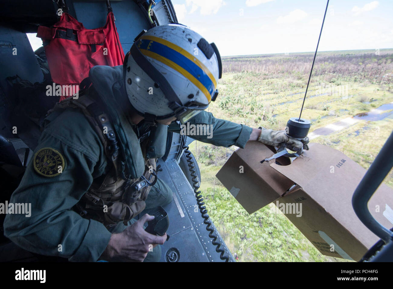 WEST, Fla (Sept. 12, 2017) Luft Crewman (Hubschrauber) 2. Klasse Sam Jeune, von Grand Rapids, Minnesota, bereitet die unteren Wasser für die Bewohner von Hurricane Irma aus einem MH-60R Sea Hawk betroffen, von den Spartans der Hubschrauber Meer Maritime Squadron (HSM) 70. Das Verteidigungsministerium ist die Federal Emergency Management Agency, die federführende Bundesamt, in denen helfen, die vom Hurrikan Irma Betroffene leiden zu minimieren und ist ein Bestandteil der gesamten-von-Reaktion seitens der Regierung. Stockfoto