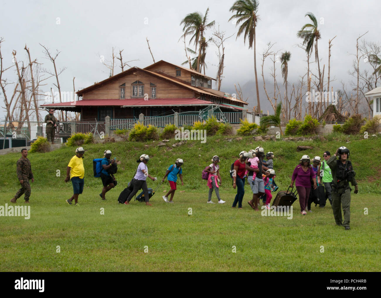 DOMINICA (Sept. 25, 2017) Naval Aircrewman (Hubschrauber) 2. Klasse Nikolaus Glas Hubschrauber Meer Combat Squadron 22 (HSC 22), angeschlossen an den amphibischen Angriff Schiff USS Wasp (LL 1), führt die Bewohner zu einem MH-60s Sea Hawk Hubschrauber zur Evakuierung nach dem Landfall Hurrikan Maria. Dominica Bewohner werden von ihrer Insel zu den nahe gelegenen Inseln Martinique und Guadalupe evakuiert. Das Verteidigungsministerium ist die Unterstützung der US-Behörde für Internationale Entwicklung (USAID), die Leitung der Föderalen Agentur, dabei helfen, die Betroffenen durch den Hurrikan Maria zu leiden eine minimieren Stockfoto