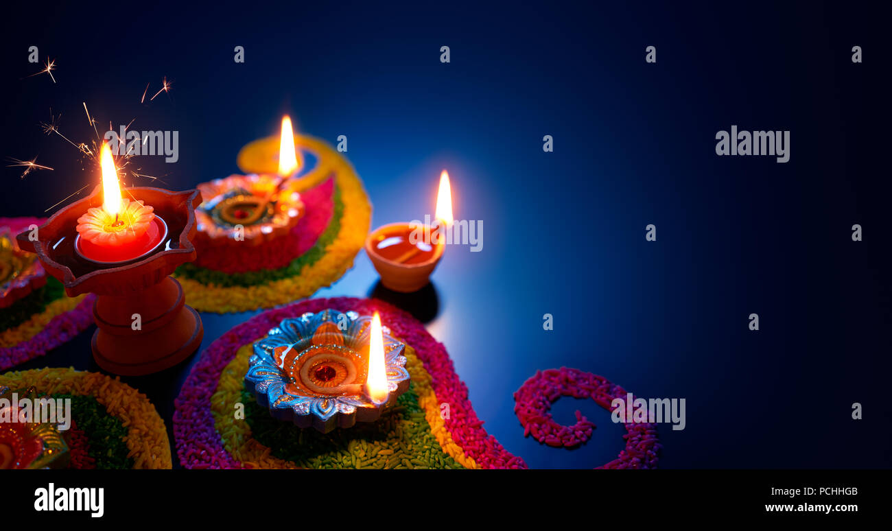 Öllampen beleuchtet auf bunten rangoli während Diwali Feier Stockfoto