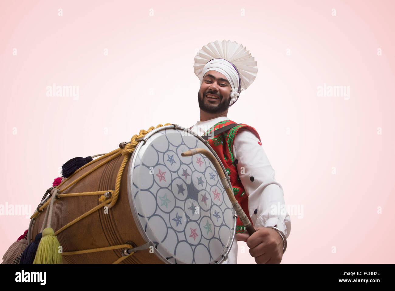 Sikh Mann spielt auf einem Dhol Stockfoto