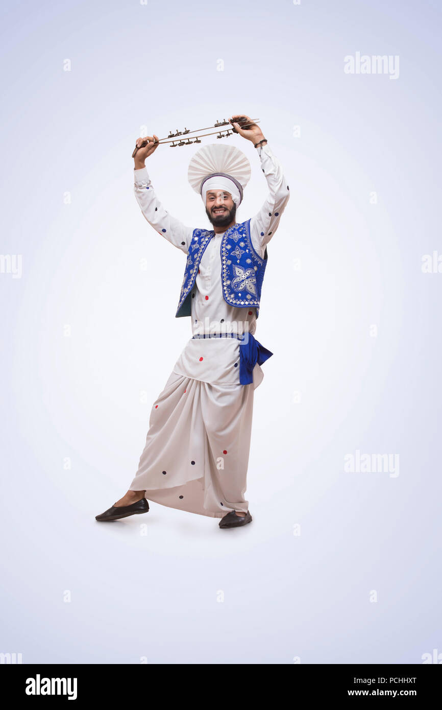 Portrait von Sikh Mann tanzen und halten eine Chimta Stockfoto