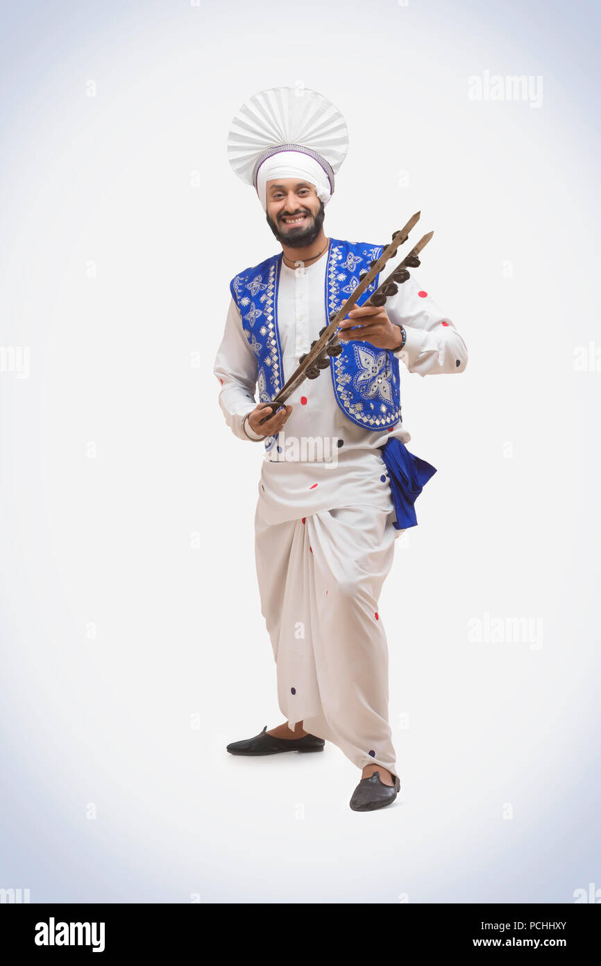Portrait von Sikh Mann tanzen und halten eine Chimta Stockfoto