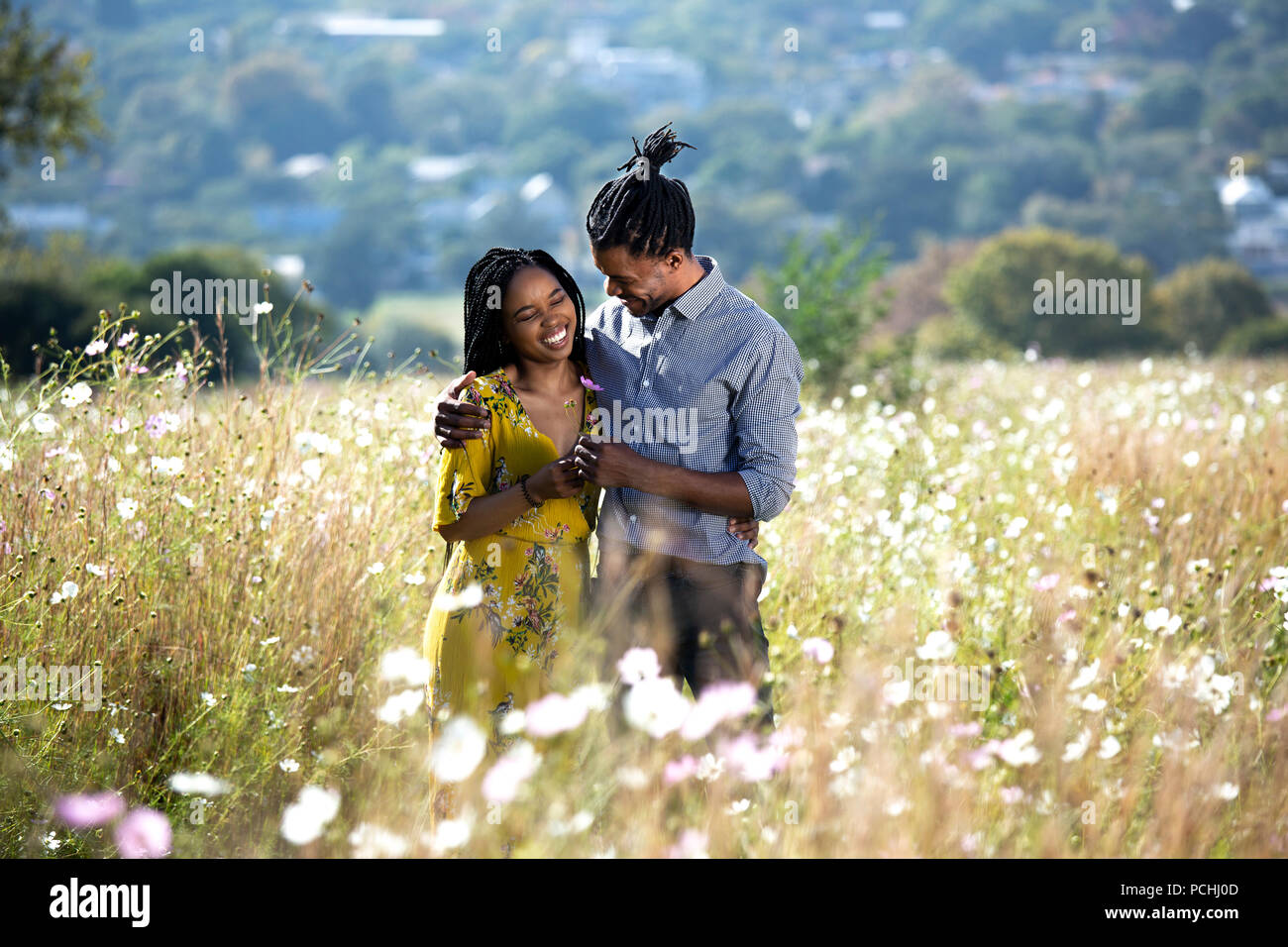 Paare, die in einem Feld von Blumen Stockfoto