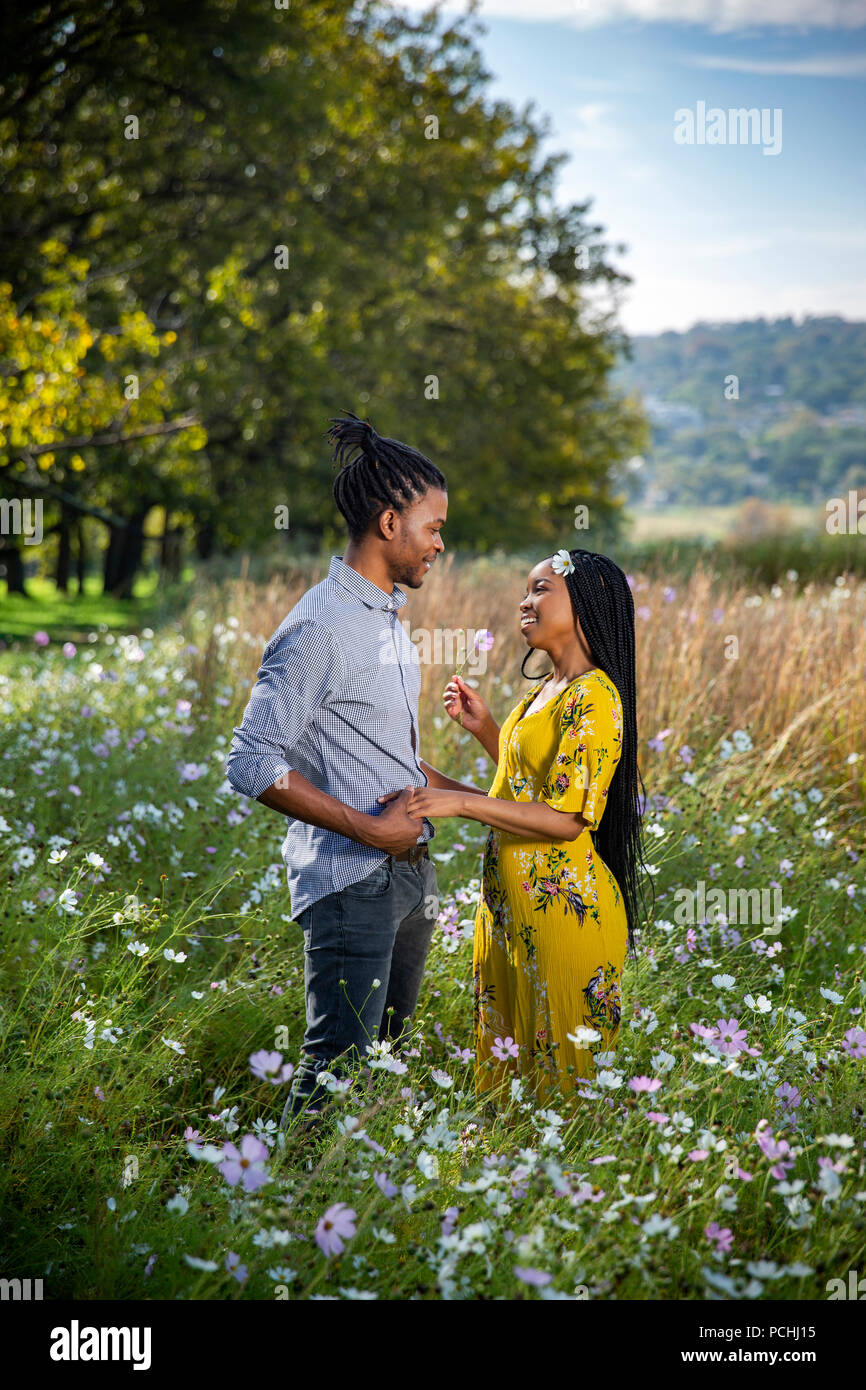 Paar in einem besonderen Moment in einem Feld von Blumen Stockfoto