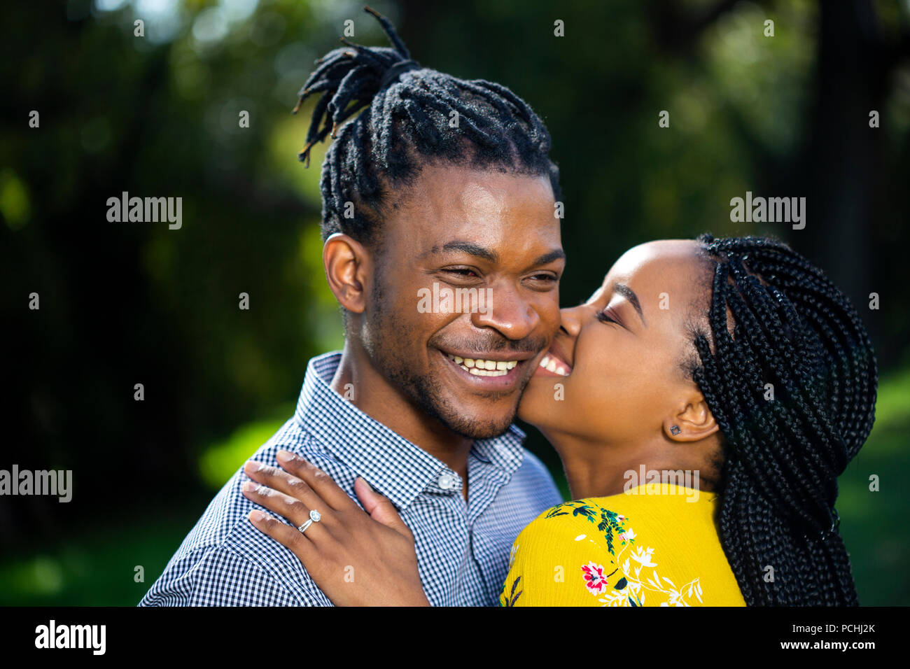 Afrikanische Frau küssen afrikanischen Mann auf die Wange Stockfoto