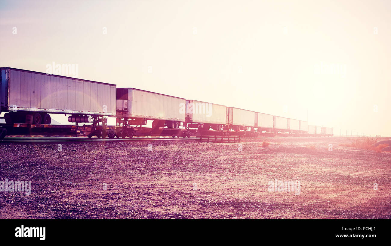 Intermodaler Güterverkehr, Auflieger auf Zug bei Sonnenuntergang, Farbe getonte Bild, USA. Stockfoto