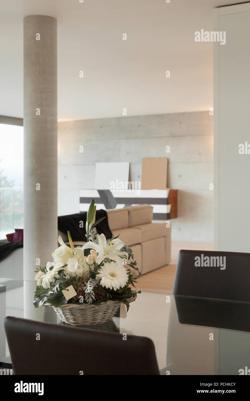 Interieur Home, moderner Esstisch mit Korb mit Blumen Stockfoto