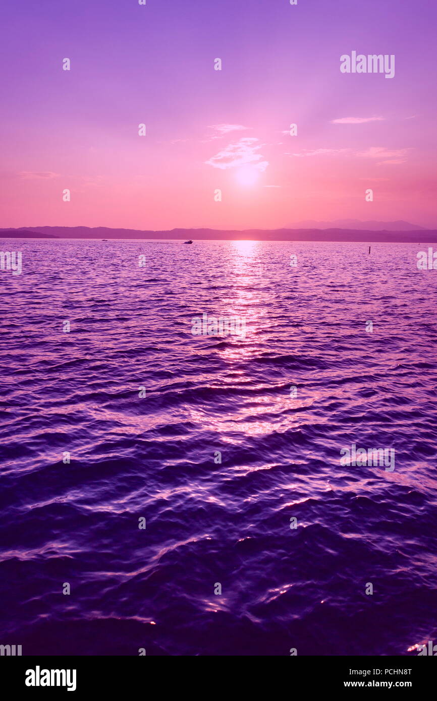 Schönen lila Sonnenuntergang mit Boot am Lago di Garda, Italien Stockfoto