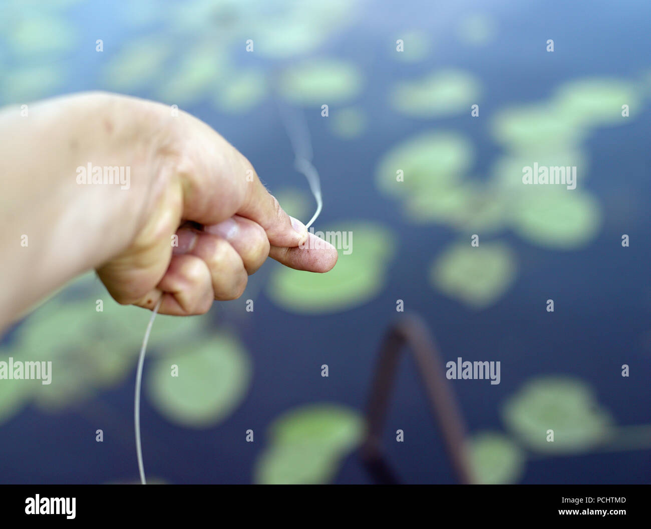 Ein Fischer ziehen Angelschnur aus Wasser, geringe Tiefenschärfe Stockfoto