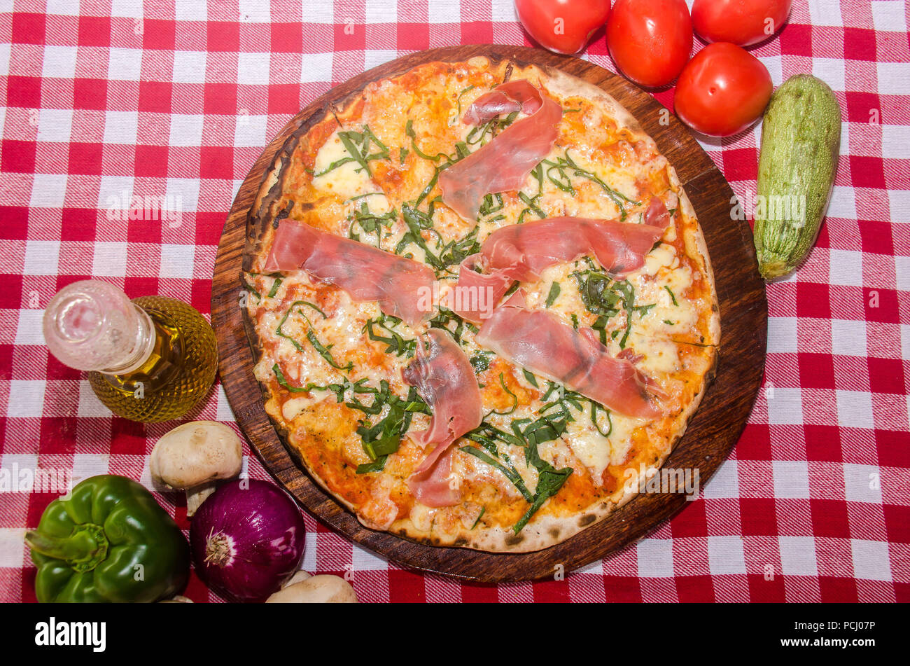 Handwerkliche Pizza auf eine Holzplatte Stockfoto