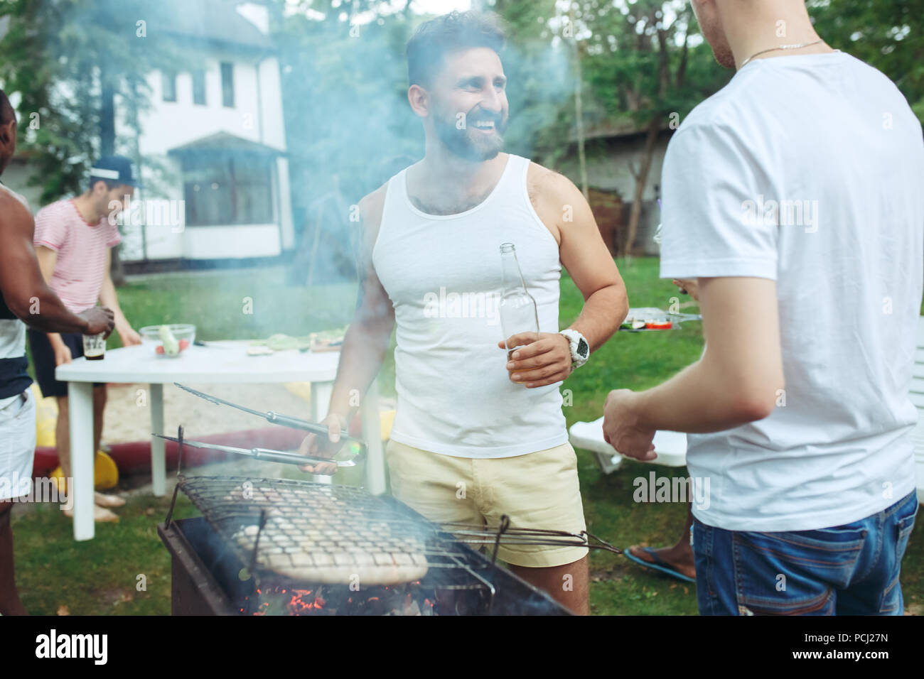 Eine Gruppe von Freunden, Grill im Hof. Konzept über gute und positive Stimmung mit Freunden Stockfoto