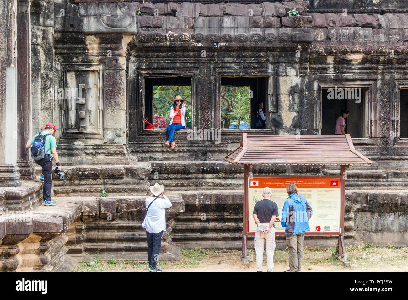 Angkor Wat, Kambodscha - 11. Januar 2018: Chinesische Touristen für Fotos posieren. Sie zeigen wenig Respekt für die antiken Ruinen. Stockfoto