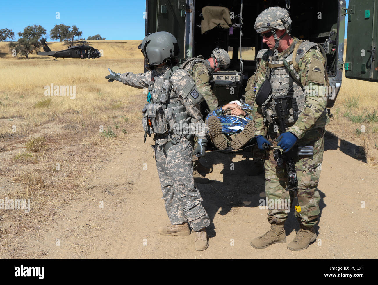 Soldaten aus 141 Der 41St Infantry Brigade Combat Team Brigade Support Bataillons mit einem Wurf einen simulierten Unfall für Medical Evacuation auf ein UH-60 Black Hawk Hubschrauber während einer Übung zu entladen, 27. Juli 2018 im Camp Roberts, Kalifornien. Die 41 IBCT ist die Durchführung einer groß angelegten Übung bekannt als exportierbar Combat Training (XCTC) Vom 21. Juli bis Aug. 12 platoon Kenntnisse über die Feuerwehr in Abstimmung mit der ersten Armee zu zertifizieren. "Diese Übung hält unsere Einheiten ausgebildet und bereit für Missionen und baut auf der Ausbildung des Brigade aus dem letzten Jahr Warfighter Stockfoto