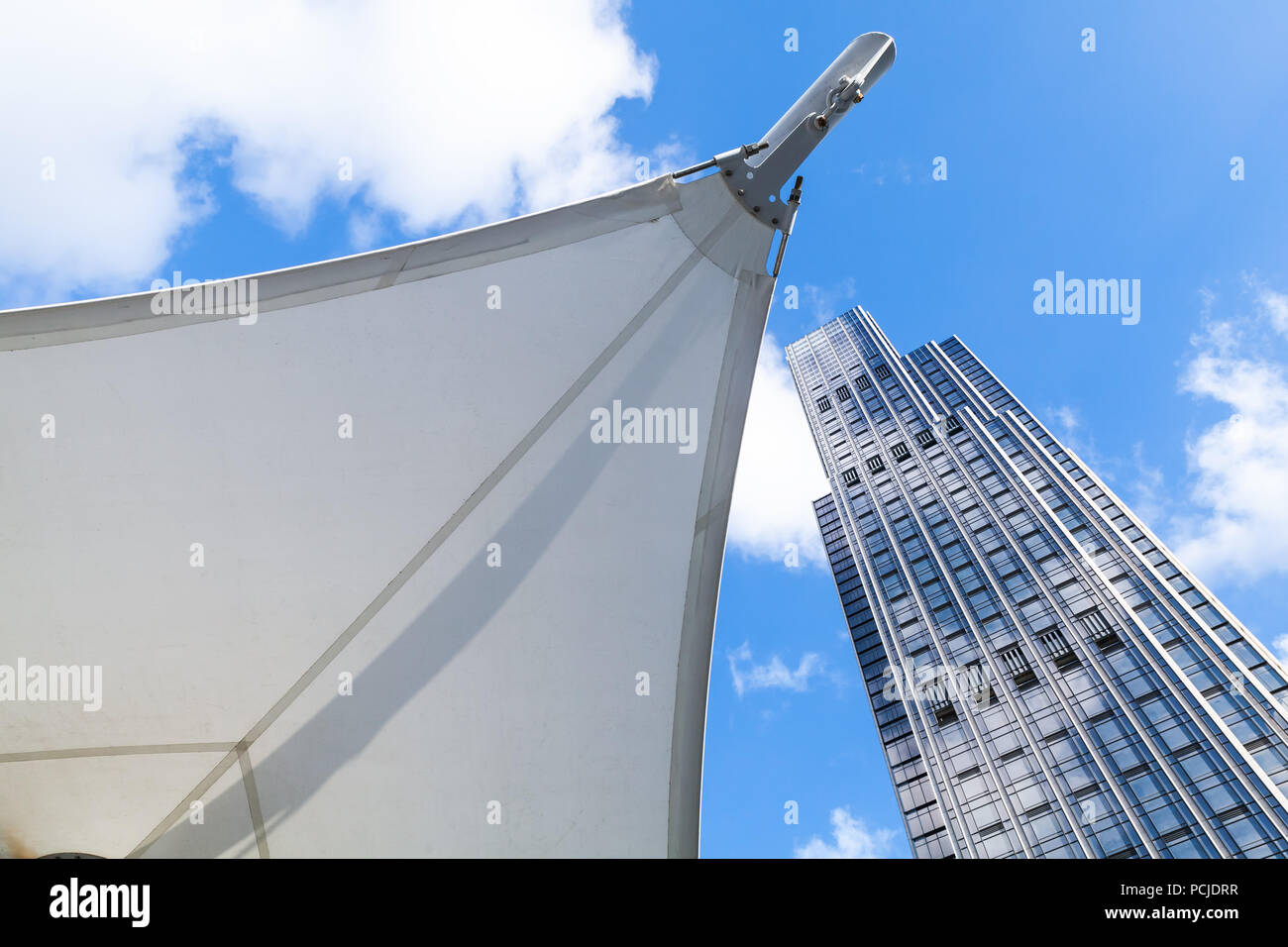 Abstrakte moderne Architektur Hintergrund Foto, Office Tower aus Glas und Stahl in der Nähe der Markise in Segel Form Stockfoto