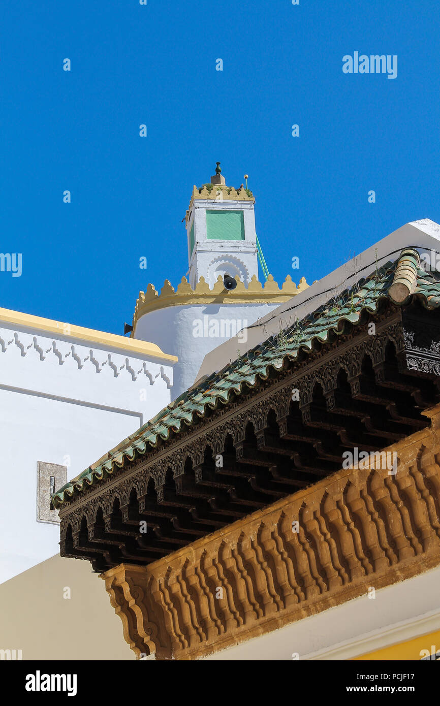 Oben auf dem Turm der Großen Moschee in der ehemaligen portugiesischen Festung von El Jadida, Marokko. Details der reich verzierte Dach im Vordergrund. Hell blau Sk Stockfoto