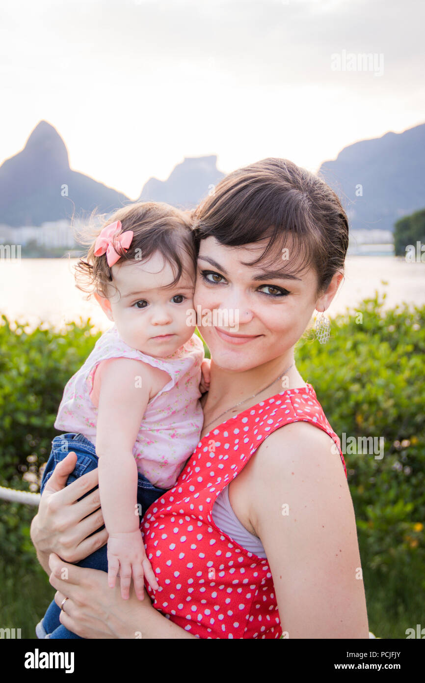Porträt einer Frau, die ihre Tochter Holding, Rodrigo de Freitas Lagune, Rio de Janeiro, Brasilien Stockfoto