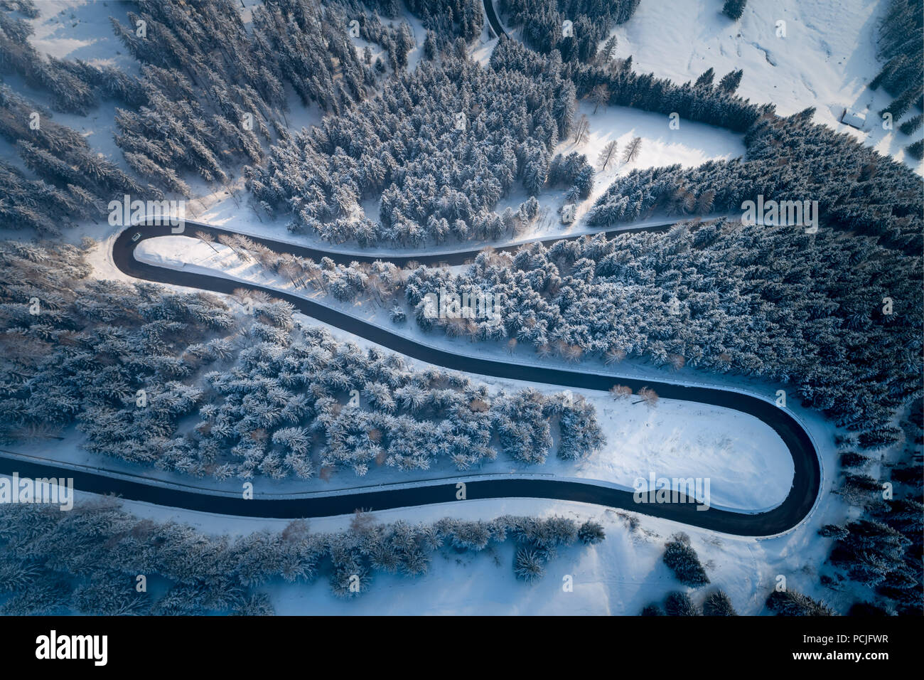 Luftaufnahme der kurvenreichen Straße durch die Berge im Winter, Salzburg, Österreich Stockfoto