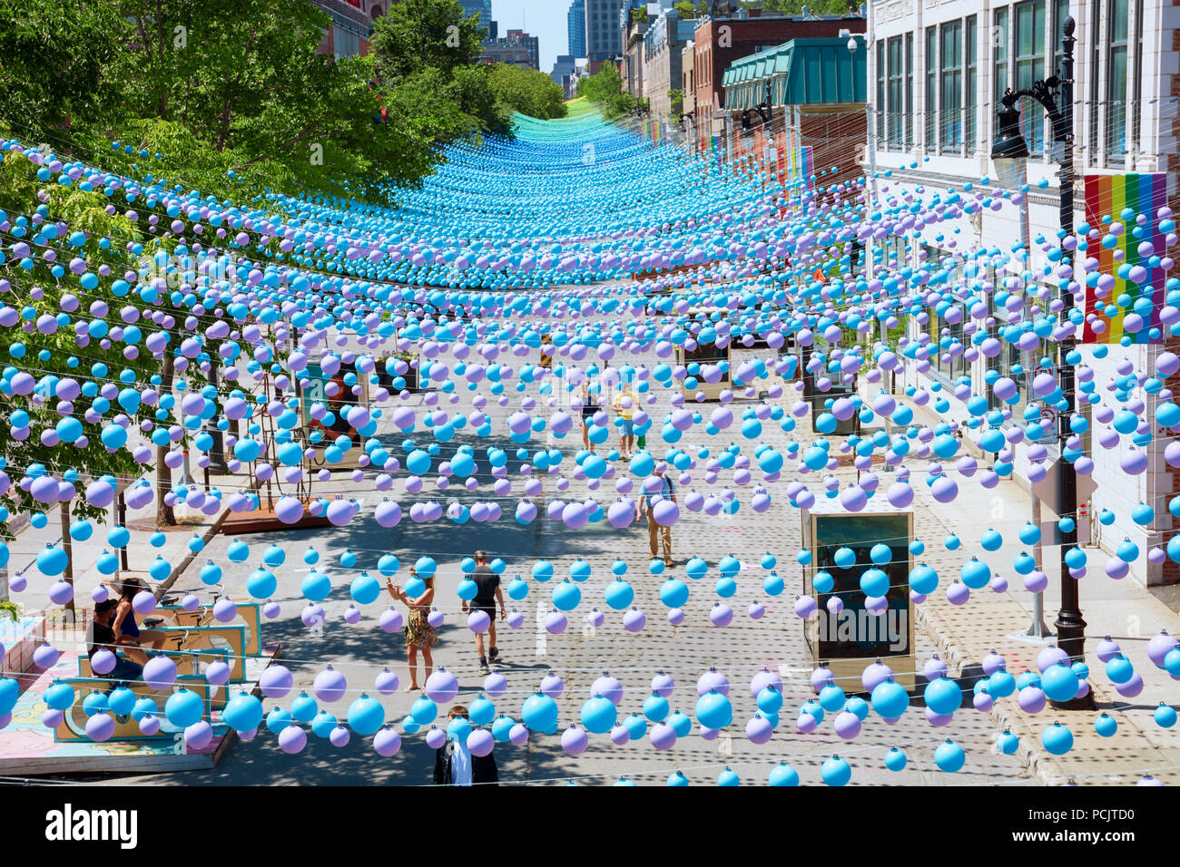 Montreal, Kanada - Juni, 2018. Kultigen bunten Regenbogen Bälle hängt über das Gay Village in der sainte-catherine Street Montreal, Quebec, Kanada. Bearbeiten Stockfoto