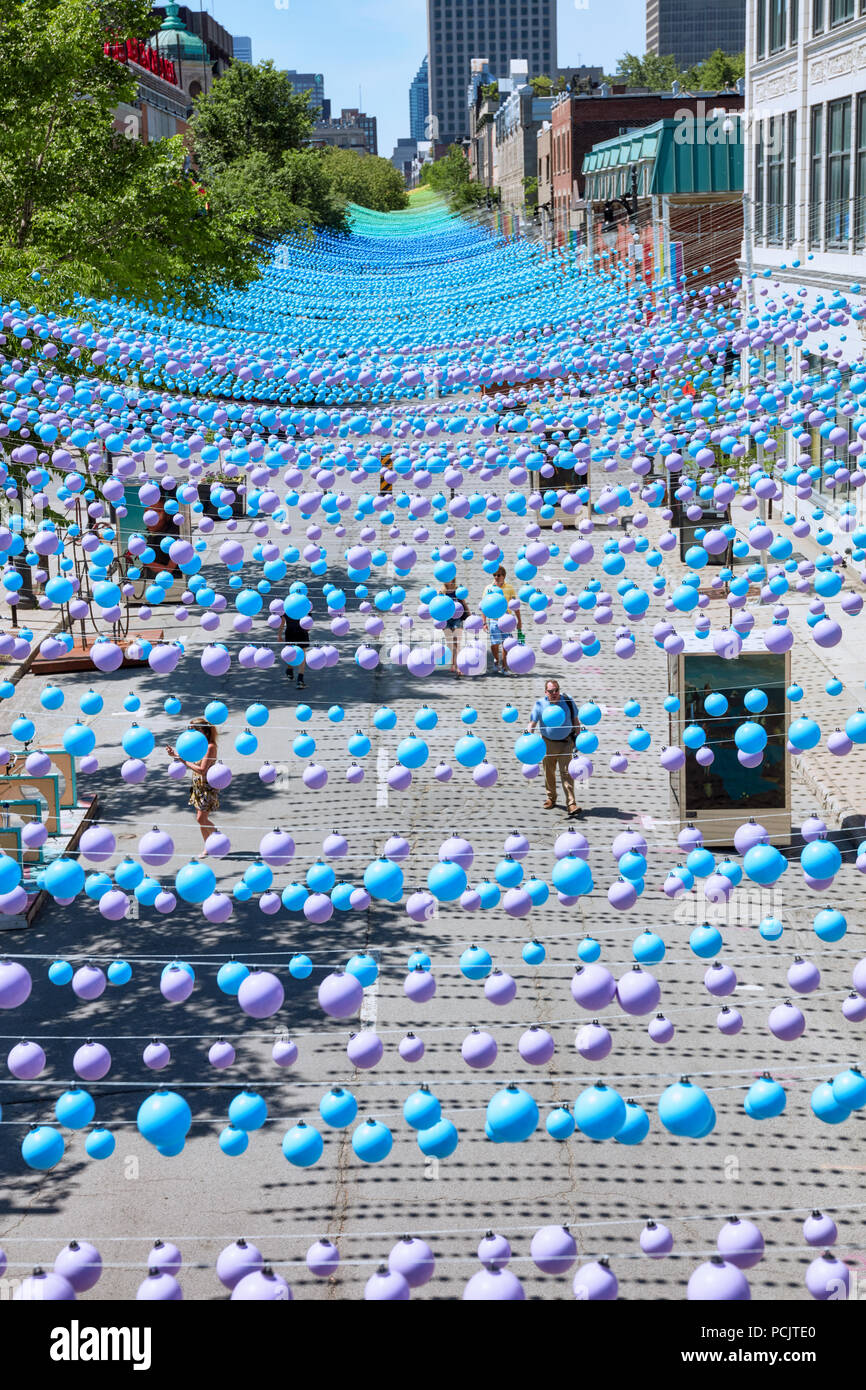 Montreal, Kanada - Juni, 2018. Kultigen bunten Regenbogen Bälle hängt über das Gay Village in der sainte-catherine Street Montreal, Quebec, Kanada. Bearbeiten Stockfoto