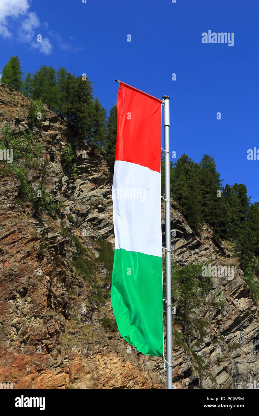 Flagge von Italien gegen Wald und blauem Himmel Hintergrund Stockfoto