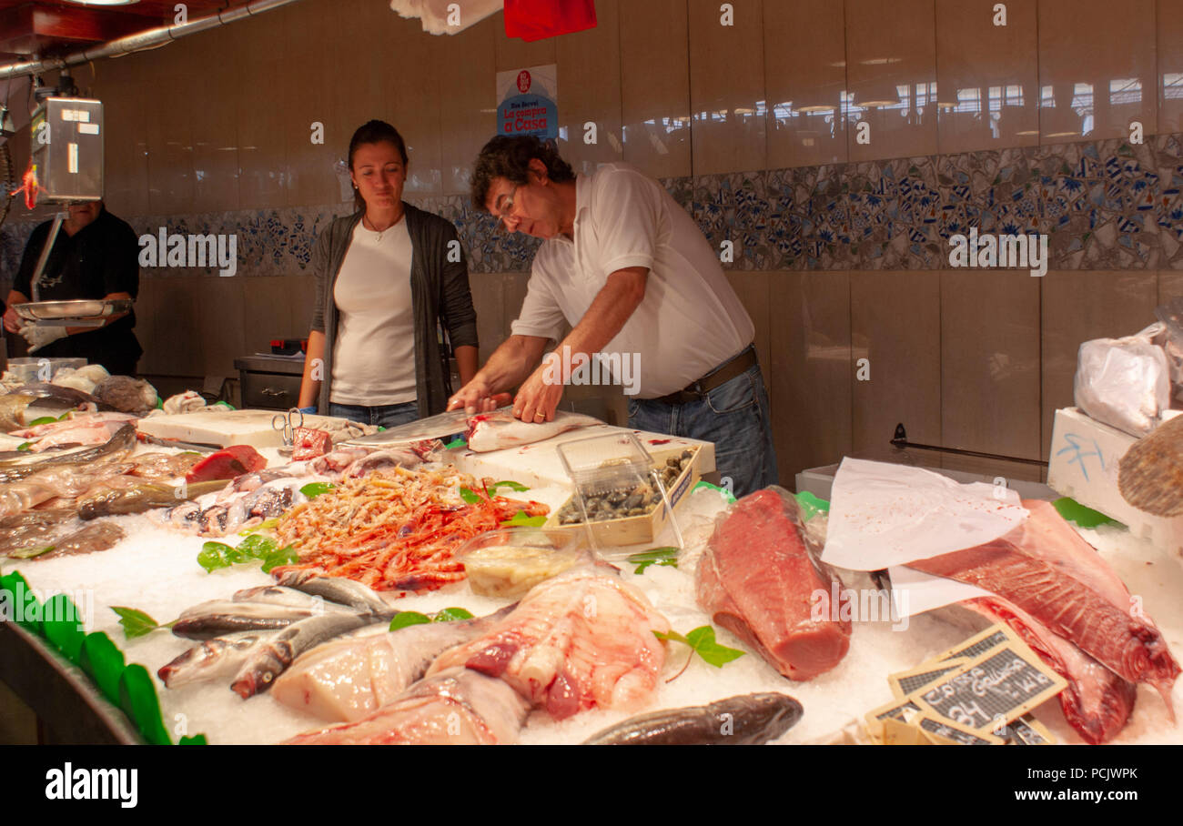 La Boqueria Markt mit frischen Lebensmitteln Barcelona Spanien Europa 2 Personen hinter der Theke eines Fisches. Der Mann ist ein Fisch ausnehmen Stockfoto