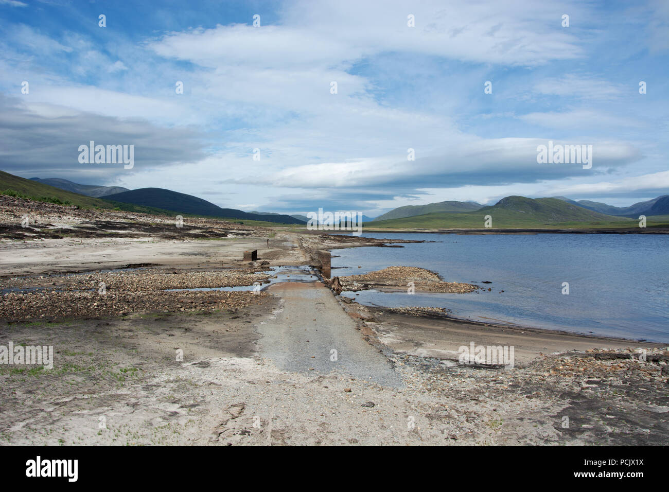 Auf der Suche nach Westen von der zweiten Brücke auf der alten Dingwall in Ullapool Road, die normalerweise unter Loch Glascarnoch versenkt. Stockfoto