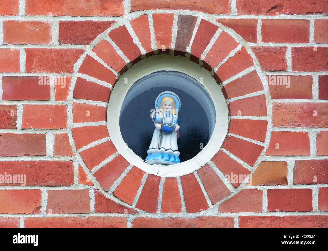 Bourtange, Niederlande, November 7, 2017: eingerichteten runden Fenster mit blauen Puppe mit Schere und Nähgarn in Ihrer Hand Stockfoto