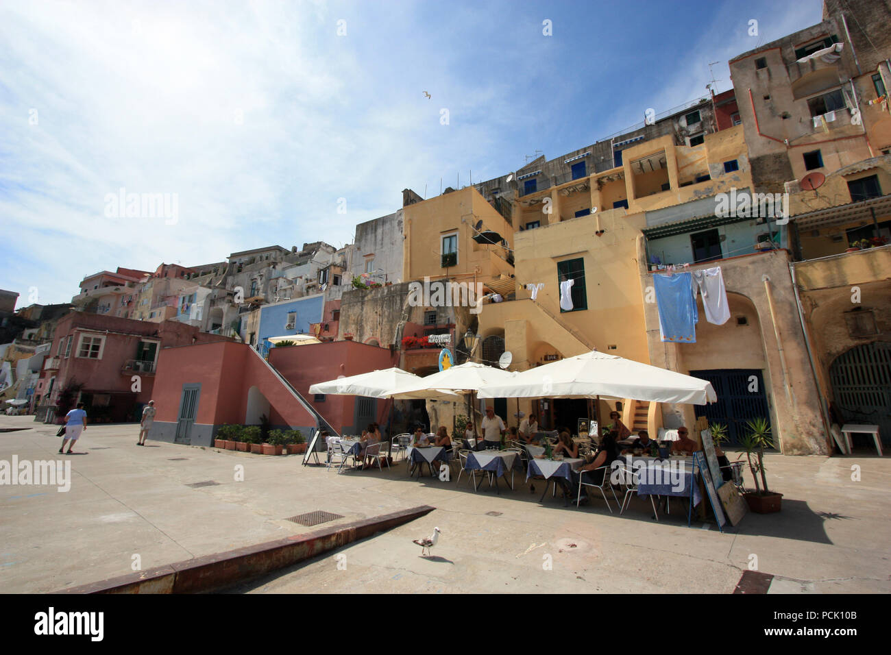 Menschen ihren Kaffee in einem Café oder in einem Restaurant an der Promenade von Corricella auf Procida, Golfo di Napoli, Italien Stockfoto
